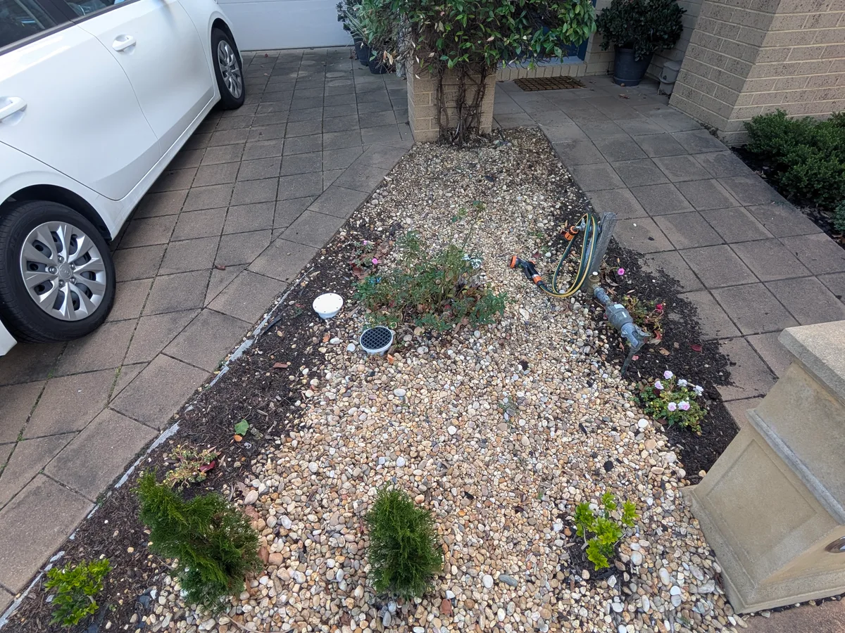 Before: narrow front garden bed with ageing mixed pebbles, sparse planting and no clear structure