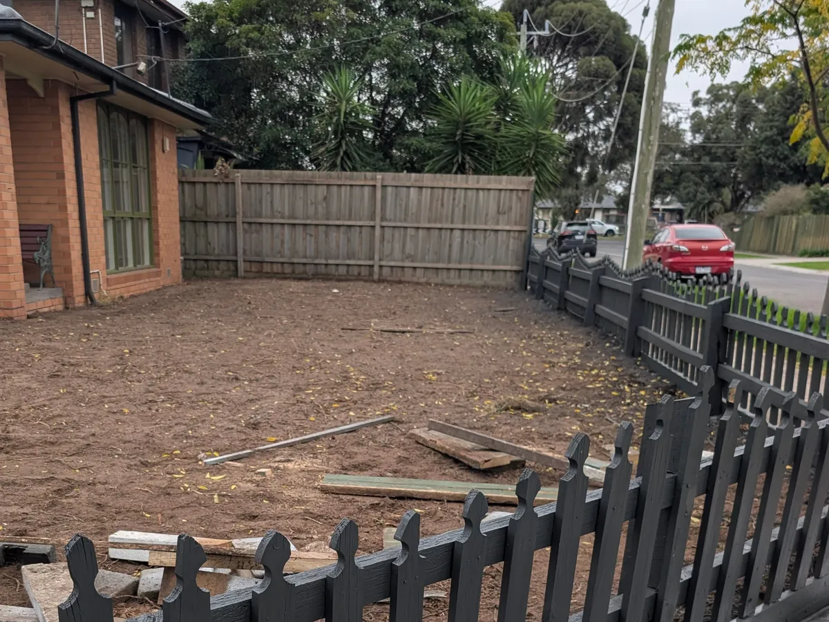 Before: the front garden stripped back to bare, uneven soil with timber offcuts left across it