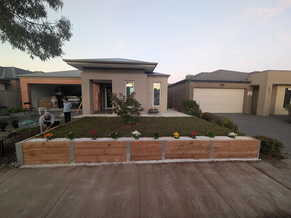 After: raised sleeper planter with fresh turf, pebbles and flowers
